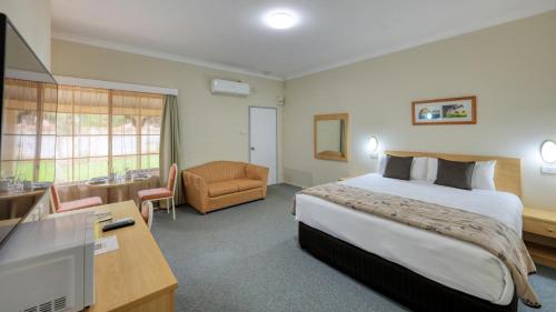 考拉乡村花园汽车旅馆 的酒店客房配有一张床、一张书桌和一台电视。
