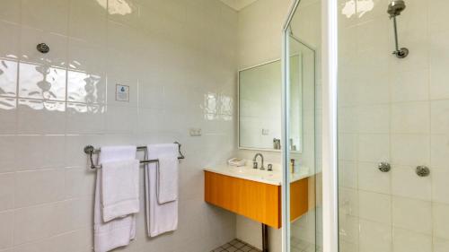 考拉乡村花园汽车旅馆 的白色的浴室设有水槽和淋浴。
