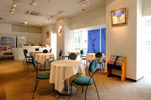 大阪2nd inn的一间带桌椅的餐厅和一间厨房