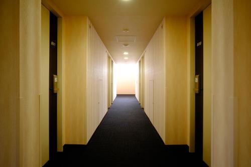 大阪2nd inn的建筑物的走廊,在尽头有灯