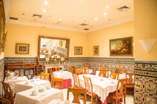 塞维利亚西尔皮斯旅馆的一间设有白色桌椅的用餐室
