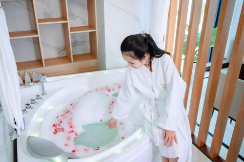 太原省The King Hotel - Condotel Thai Nguyen的一个小女孩站在浴缸里,身上有血