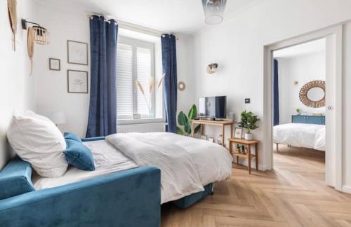 斯特拉斯堡Appart Deluxe Privé Strasbourg Centre avec Parking gratuit的一间卧室配有一张床和一张蓝色的沙发