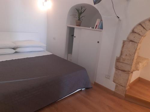 普蒂尼亚诺A Levante的一间卧室设有一张床和一个拱门