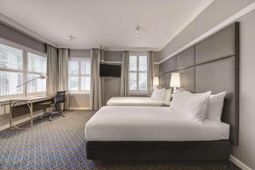 堪培拉堪培拉库拉降酒店的酒店客房配有两张床和一张书桌