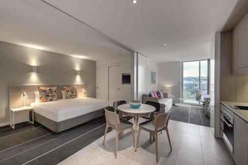 悉尼悉尼邦迪海滩阿迪娜公寓式酒店的酒店客房带一张床、一张桌子和椅子