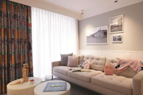 悉尼齐本德尔阿迪娜公寓酒店的客厅配有沙发和桌子