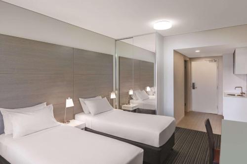 达尔文达尔文海滨阿迪娜公寓酒店的酒店客房带两张床和一间浴室