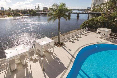 黄金海岸黄金海岸韦伯酒店的一个带椅子的游泳池,享有水景