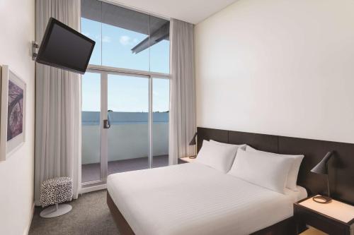珀斯阿迪娜珀斯公寓酒店的一间卧室设有一张床和一个大窗户