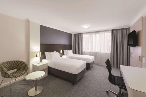 珀斯珀斯中心酒店的酒店客房配有两张床和一张书桌