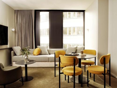 悉尼A by Adina Sydney的客厅配有沙发和桌椅