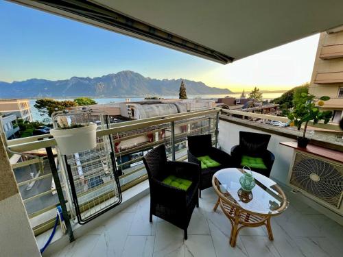 蒙特勒Fabulous Lakeside Family Apartment | 4 Rooms的设有一个配有桌椅并享有美景的阳台。