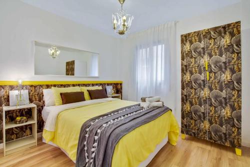 马拉加MÁlaga Playa的一间卧室配有一张带黄色毯子的大床