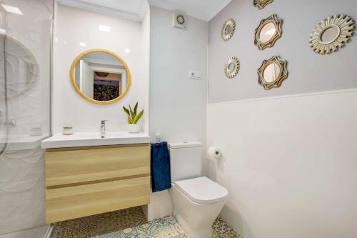 马拉加MÁlaga Playa的一间带水槽、卫生间和镜子的浴室