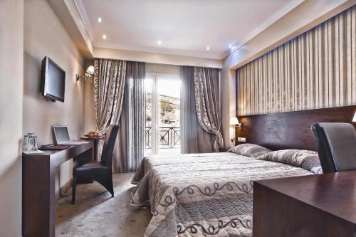 弗洛里纳费顿温泉酒店 的配有一张床、一张书桌和一扇窗户的酒店客房