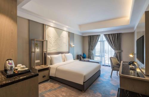 海米斯穆谢特Aber Khamis Mushait的酒店客房设有一张大床和一张书桌。