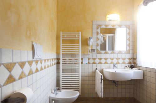 福尔加里亚Grand Hotel Biancaneve的浴室设有2个水槽和镜子