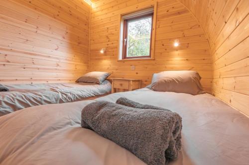 纽马基特Outdoor Inns - Star at Lidgate的小木屋内一间卧室,配有两张床
