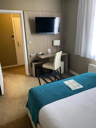 弗农诺曼底酒店的酒店客房配有一张床、一张书桌和一台电视。