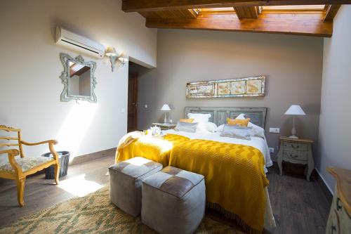 ValdelagunaCasa Rural Valle de la Laguna的一间卧室配有一张带黄色毯子的大床