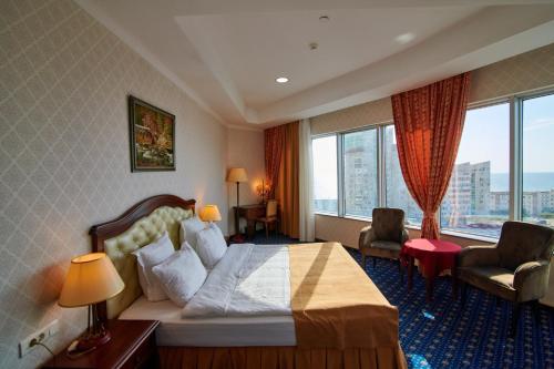 阿克套胜利大酒店的酒店客房设有一张床和一个大窗户