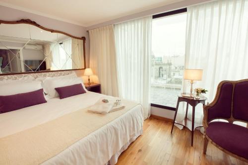 蒙得维的亚阿尔玛古典精品酒店的一间卧室设有一张大床和一个大镜子