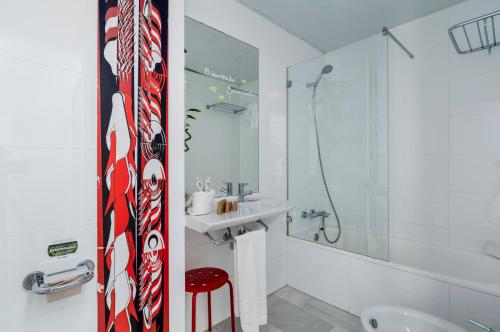 马拉加画家酒店的白色的浴室,墙上有红白色的领带
