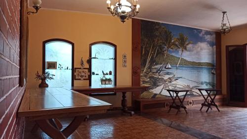 伯迪亚哥Pousada Praia Sol do Indaiá的一间设有桌子和墙上绘画的用餐室
