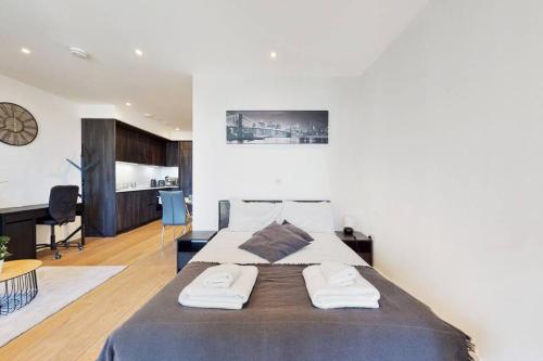 伦敦Superb Studio in Greenwich with balcony & roof top的一间卧室配有一张大床和两条毛巾