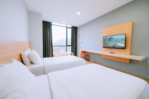 瓜埠Chill Suites Langkawi的一间酒店客房,设有两张床和电视