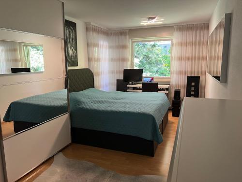 巴登-巴登Deluxe Apartment Baden-Baden的一间卧室设有两张床、一张桌子和一个窗口。