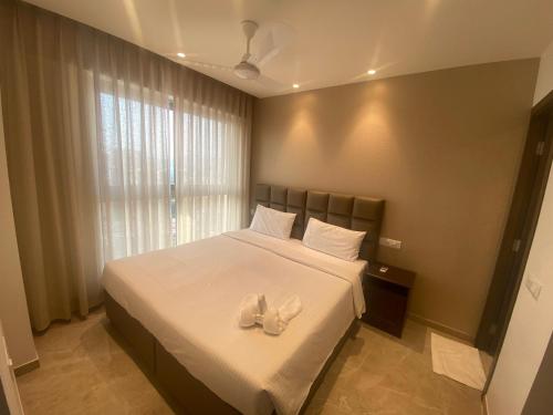 孟买Maxxvalue Apartment Hiranandani Powai - RH5的一间卧室,床上有白色的鞋