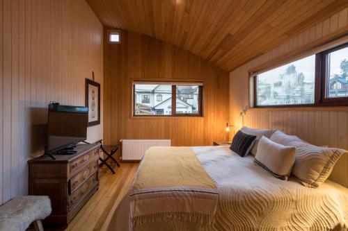 卡斯特鲁Bledford Chiloé的一间卧室配有一张床和一台电视