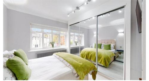 伦敦9 Brentwood Lodge的白色卧室配有两张带绿床单的床