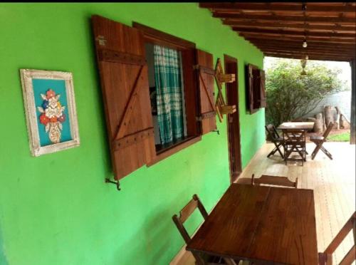 西波山Casa das Violetas - Serra do Cipó的庭院上带木桌的绿色墙壁