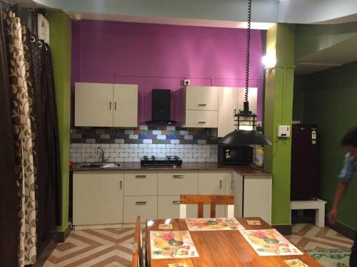 因帕尔LEISHA Duplex的厨房配有桌子和紫色墙壁