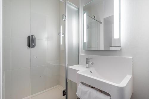 马赛B&B HOTEL Marseille Euromed的白色的浴室设有水槽和淋浴。