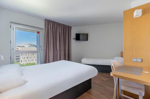 马赛B&B HOTEL Marseille Euromed的酒店客房设有床和窗户。