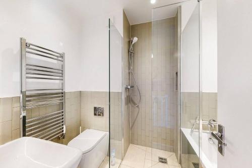 伦敦Charming 2-bedroom maisonette with private garden的一间带卫生间和玻璃淋浴间的浴室