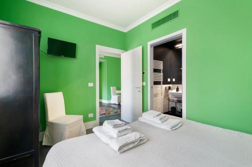 博洛尼亚Green House city center的绿色客房,配有带毛巾的床