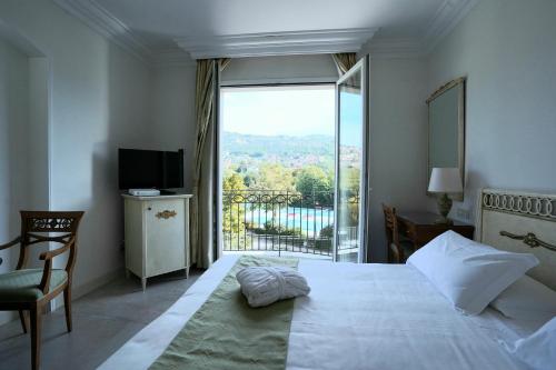 菲乌吉HOTIDAY Resort Fiuggi的一间卧室设有一张床和一个大窗户