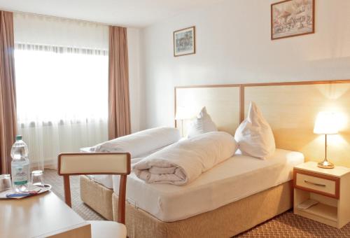 莱茵河畔威尔Hotel Ganita Weil am Rhein的酒店客房,配有两张带白色床单的床