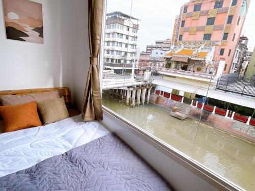 曼谷Lively and cozy canal house ,Entire house的一间卧室设有窗户,享有城市美景