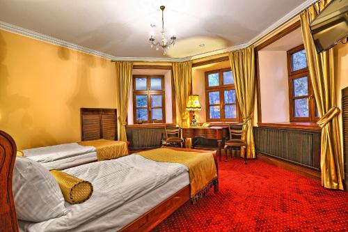 ZarzeczeDwór Słupia的一间卧室设有两张床、一张桌子和窗户。