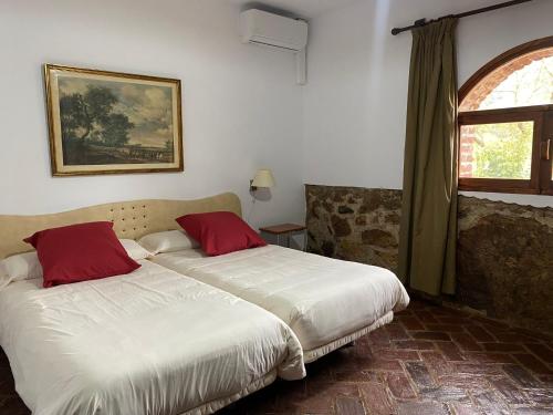 AlmendralCasas Rurales Monasterio de Rocamador的一间卧室设有两张床和窗户。