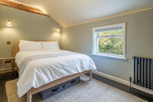 PeasenhallTipple Cottage的一间卧室设有一张大床和窗户