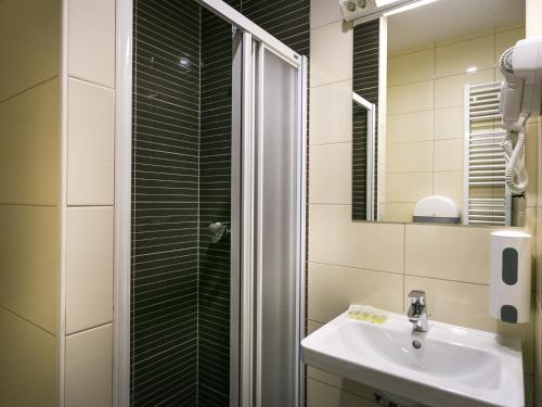 萨格勒布沐风旅舍的带淋浴、盥洗盆和镜子的浴室