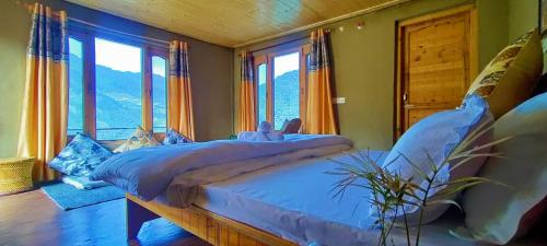 MalothaDhauladhar Woodhouse的一间卧室配有一张带蓝色床单和窗户的床。