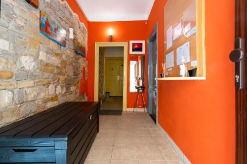 科佩尔Hostel Martin的走廊上设有橙色墙壁和木凳